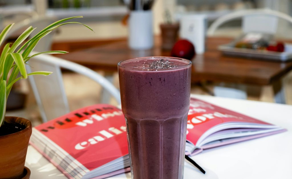 A rich, creamy blackberry smoothie served on a café table, perfect for a healthy breakfast.